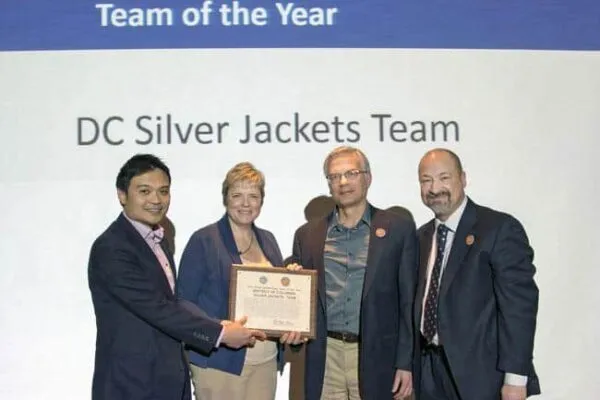 From left, Phetmano Phannavong, DC Department of Energy and Environment, DC floodplain manager; Stacey Underwood, U.S. Army Corps of Engineers, Baltimore District, Silver Jackets Program coordinator; and Mark Baker, National Park Service, Dam and Levee Safety officer, are recognized as part of the District of Columbia Silver Jackets Team as state Silver Jackets team of the year, during the Silver Jackets national workshop in St. Louis, March 2, 2017. Mark Roupas (at right), Corps, Office of Homeland Security deputy chief, presented the team members with the award during the workshop. The Corps Baltimore District, NPS and DOEE jointly lead the DC Silver Jackets, which is an interagency team that manages flood risks in the District. There are active Silver Jackets teams in 47 states, plus the District, and the program is sponsored by the Corps. Photo: George Gonzalez | D.C. team that manages flood risks is recognized nationally