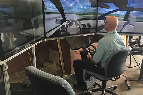 Denny Kovalick, test track manager for the Larson Transportation Institute, at Penn State, takes the highway driving simulator for a test drive before the 2017 Pennsylvania Automated Vehicle Summit. IMAGE: PENN STATE | Grant to study how driver behavior is impacted by autonomous vehicle technology