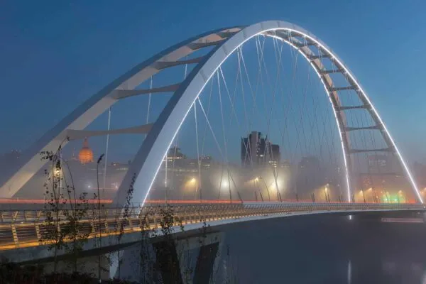 At night, the edges of the iconic arches are elegantly illuminated in white. Lighting design by HLB Lighting Design. | The iconic new Walterdale Bridge connects the city, nature, and people