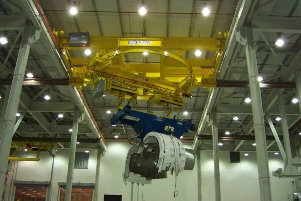 J&B designed a carrier (blue) for the jet engines, which was lifted by the circular crane system. | Acco Overhead Crane Solution for Aerospace Manufacturer