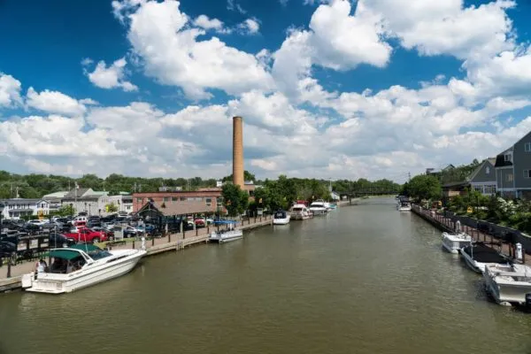 Erie canal with boats and buildings on a summer day in Fairport, New York | Erie Canal’s $300 Million Reimagining Unveiled by New York State