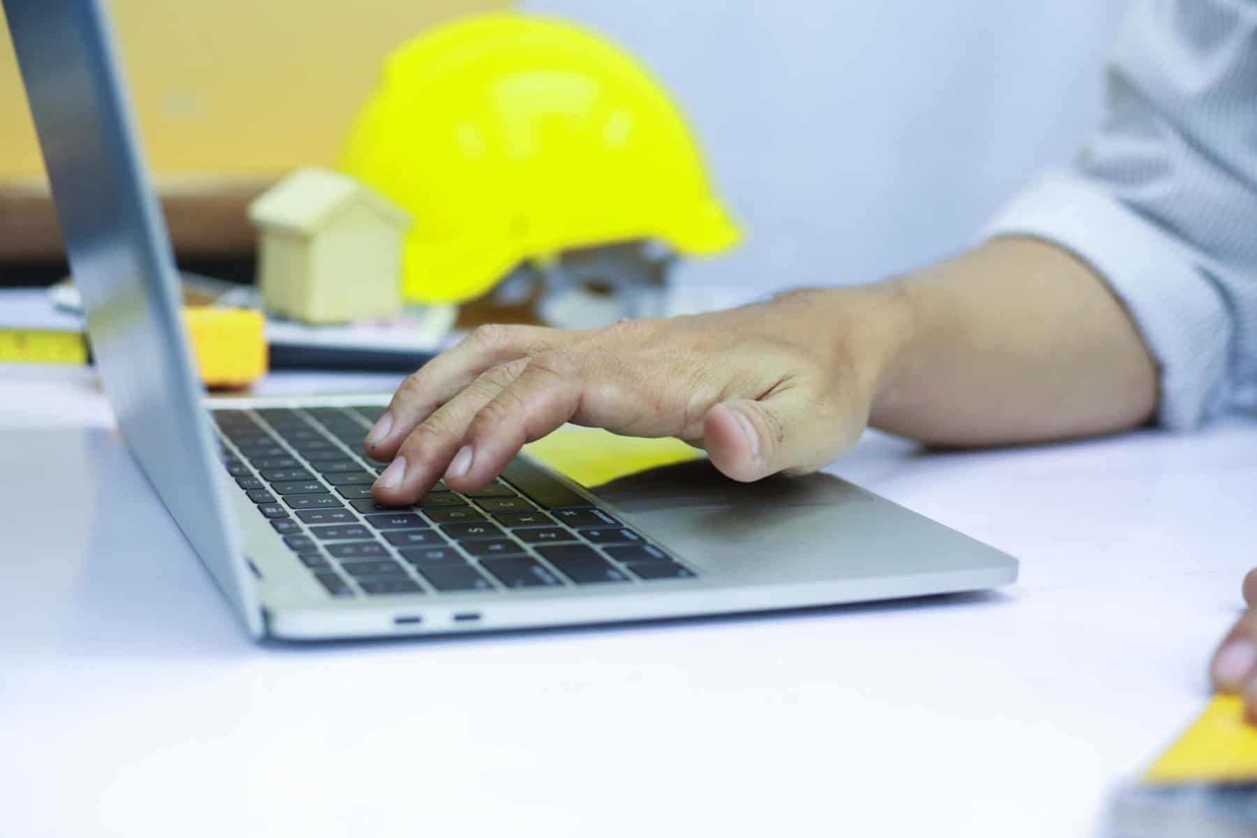 Engineering is designing a home construction project on a computer. | Tips for Implementing SaaS in Construction