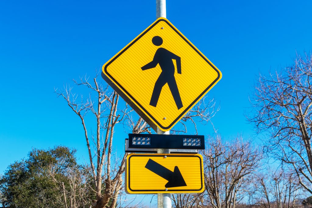 Pedestrian crossing sign with flashing lights. Crosswalk beacon