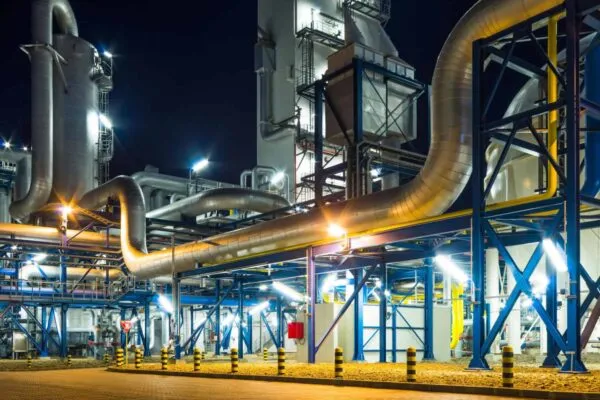 pumps and piping system inside of industrial plant at night | Global community meets to further the environmentally sound management of chemicals & waste