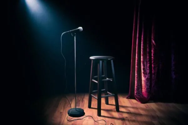 microphone on a stage with wooden stool | How to Catch a Rising Star