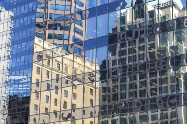 Reflections of old buildings in the windows of modern city office building tower | Nextech AR Signs a Multi-Event, LiveX Platform Deal and Strategic Partnership with FENEX to Resell Its Augmented Reality Solutions to the UK Home Remodeling and Builder’s Community