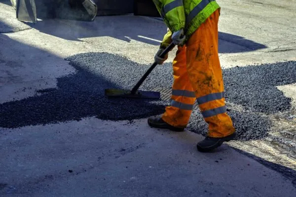 worker leveling fresh asphalt during asphalt pavement repair or construction works | ERDCWERX, ERDC Seek Commercialization Partners for Pavement Repair Technology