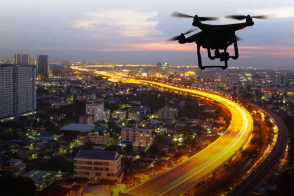 Silhouette of drone flying above city at sunset | Emerging Commercial Drones Industry set Massive Growth in Construction & Aviation Sector