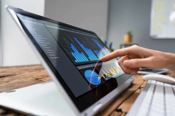 Close-up Of A Businesswoman's Hand Analyzing Graph On Laptop At Workplace | Smart, Predictive Data is Driving the Future of the AEC Industry