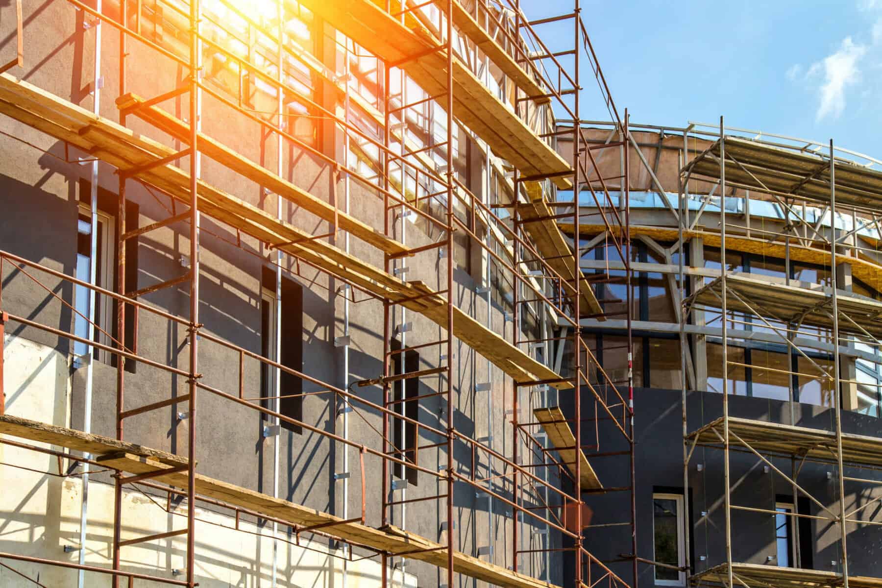 Extensive scaffolding providing platforms for work in progress on a new apartment block,Tall building under construction with scaffolds,Construction Site of New Building | Forming & Shoring Solutions Receives 2021 SAIA Innovative Project Of The Year