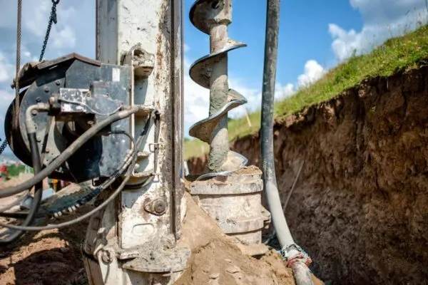 Close up of auger, industrial drilling rig making a hole in the ground | Edwards-Pitman Environmental Joins Braun Intertec