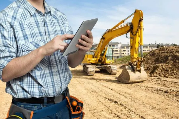 Worker using a tablet in a constuction site | ZEPTH ADVANCES THE FUTURE OF CONSTRUCTION BY INTEGRATING PROJECT MANAGEMENT SOFTWARE WITH MOBILE ROBOTICS