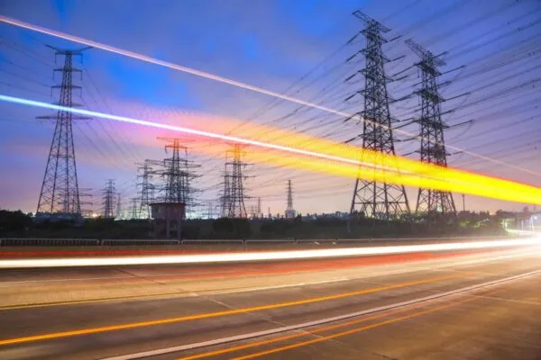 High voltage, high speed road car track in the background of high voltage towers | Bentley Systems Enters into Agreement to Acquire Power Line Systems, Global Leader in Software for Power Transmission Engineering