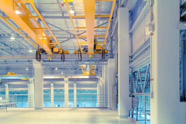 Overhead crane and concrete floor inside factory building for background. | American Equipment Completes Acquisition of Washington Crane & Hoist