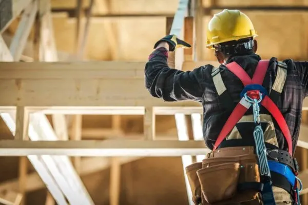 Wood Construction Worker. Caucasian Builder Wearing Safety Harness and the Wooden House Structure. Industrial Theme. | Attracting Next Generation’s Technical Workforce