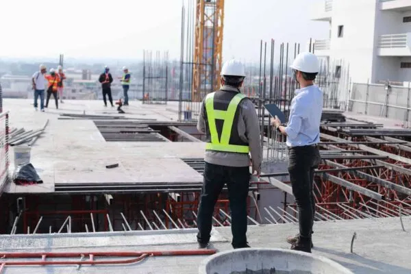 Two engineers work on the construction site. They are checking the progress of the work. | AECOM to provide construction management services for Whittier Union High School District Measure AA bond program