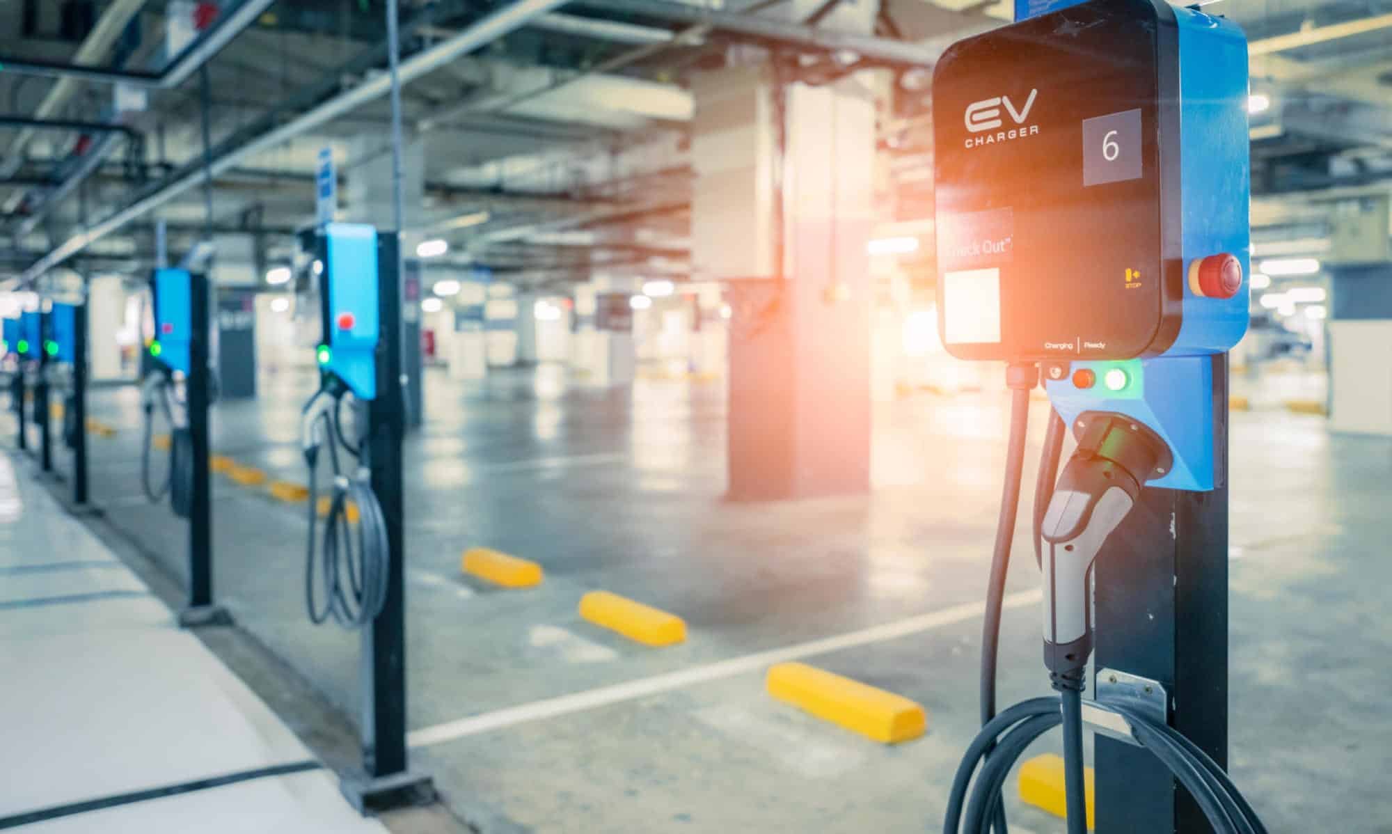 Electric car charging station for charge EV battery. Plug for vehicle with electric engine. EV charger. Clean energy. Charging point at car parking lot. Green power. Future transport technology. | First ever advanced EV charging system addresses enormous challenges faced by fleet, multifamily property owners