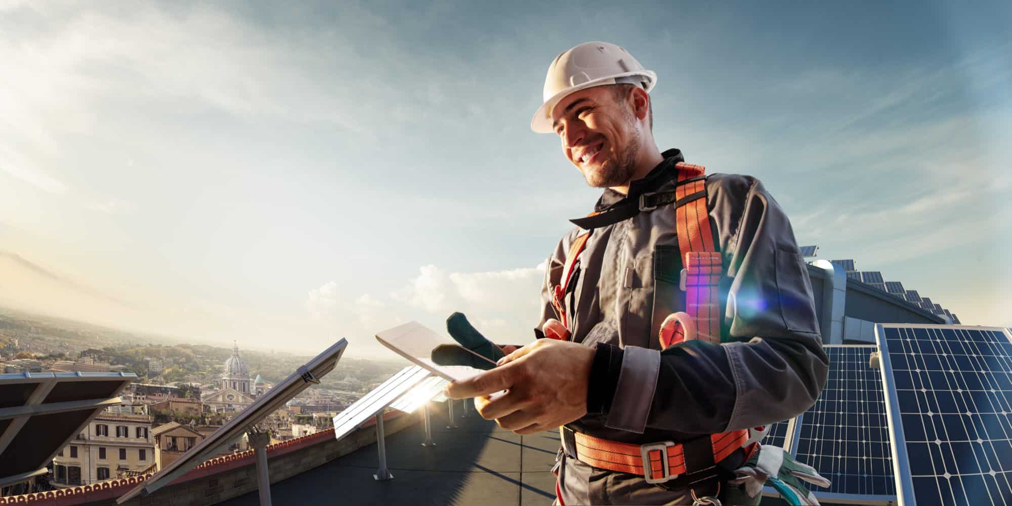 Solar energy engineer using tablet for check power station in roof | Bowman Consulting Group Ltd. Expands Building Services and MEP Practices Through Acquisition of Towson Based Kibart, Inc.