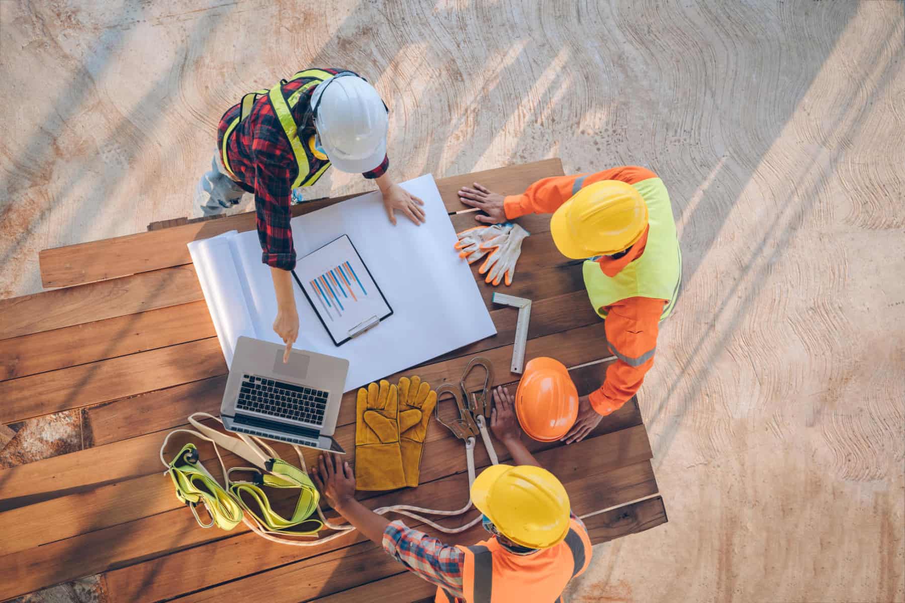 Team of engineer and architects working, meeting, discussing,designing, planning, measuring layout of building blueprints at construction site,Top view,Construction concept. | ABC’s Construction Backlog Slips Again in January; Contractor Confidence Inches Lower