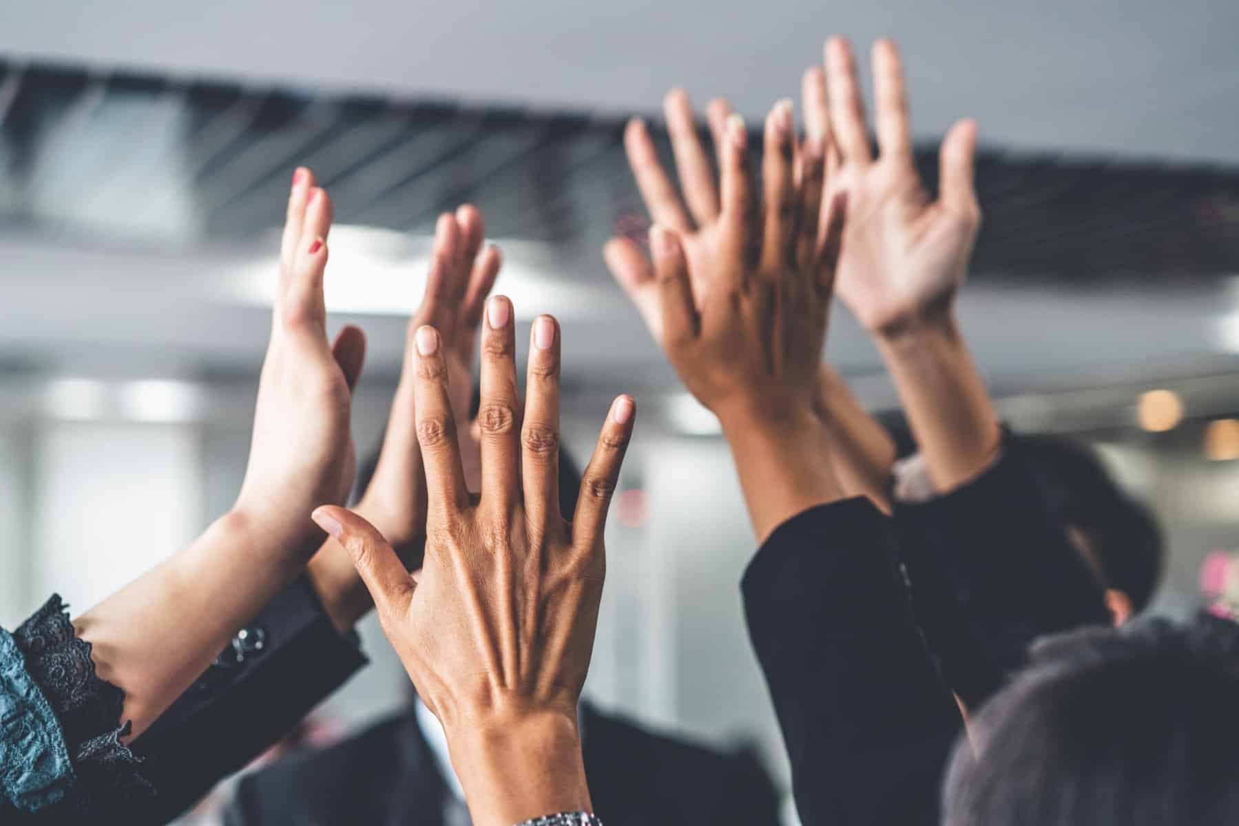 Many happy business people raise hands together with joy and success. Company employee celebrate after finishing successful work project. Corporate partnership and achievement concept. | Celebrating Wins and Preparing for the Future