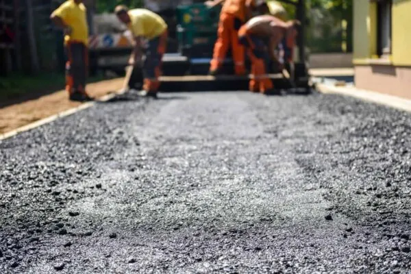 Team of Workers making and constructing asphalt road construction with finisher. The top layer of asphalt road on a private residence house driveway | Leading Asphalt and Aggregates Industry Event is the Next Venue of Command Alkon’s Latest Developments