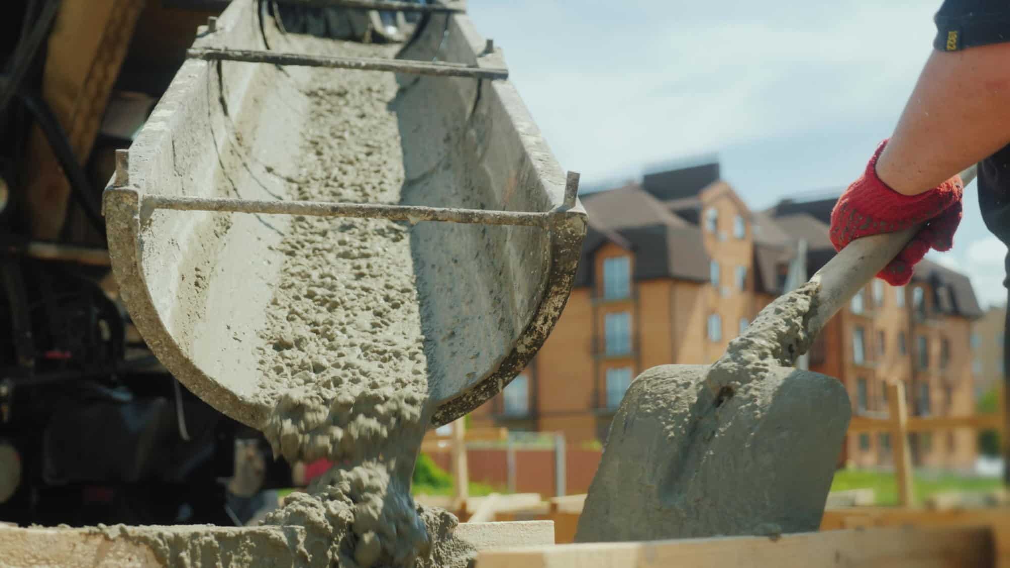 Building a cottage. Workers take concrete from a mixer into a wooden formwork. | CarbonCure Celebrates Field-Leading Carbon Removal Partners