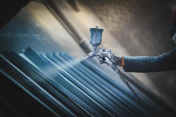 Man painting metal products with a spray gun | AZZ Inc. to Acquire Precoat Metals from Sequa Corporation