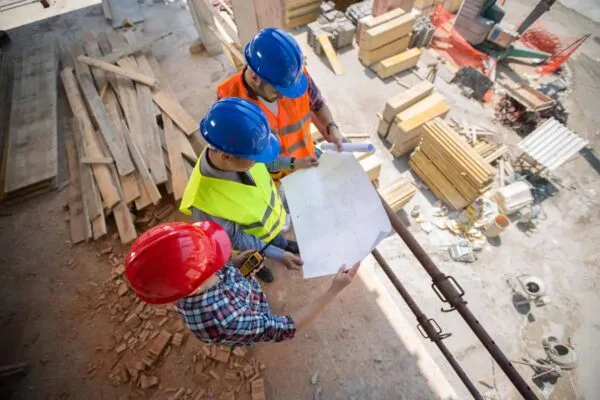 Top view of young workers checking blue print at building place | LafargeHolcim US and Legacy Brands Unite as Holcim US