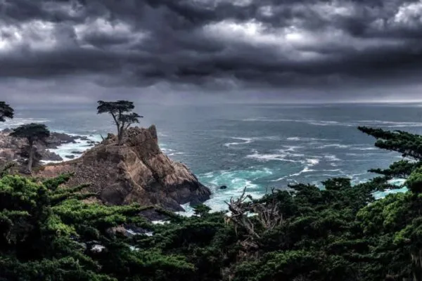 Landscape with the Lone Cypress tree on a cliff by the Pacific Ocean showing resilience and strength by withstanding storms.  The image depicts endurance in nature as a tourist attraction in California USA. | Coastal Resilience in the U.S.: The Importance of Short-Term Adaptation for a Sick World