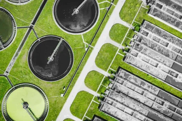 Sewage farm. Static aerial photo looking down onto the clarifying tanks and green grass. Geometric background texture. | OC San and 374Water Enter into an Agreement to Deploy the First Commercial-Scale AirSCWO System