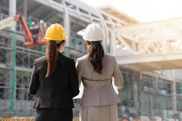 Two Asian girl architect looking at their building project with confidence. On a back view. | Increasing the Number of Women in the Construction Industry