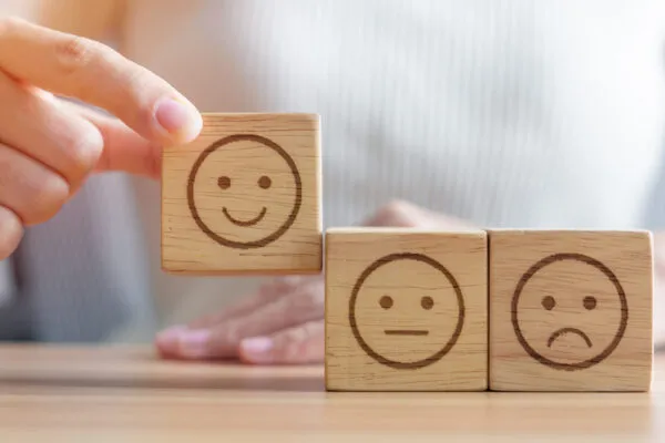 Hand choosing smile face from Emotion block.  customer review, good experience, positive feedback, satisfaction, survey, rating service, assessment, mood, world mental health day concept | Actions speak louder than words
