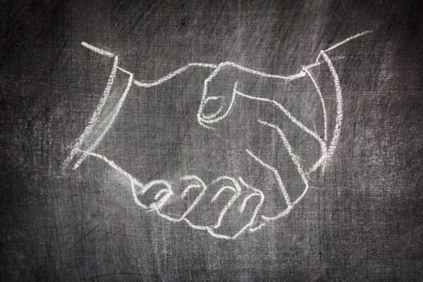 business deal handshake illustrated on a blackboard in white chalk scratched | RMA Announces the Acquisition of C Below