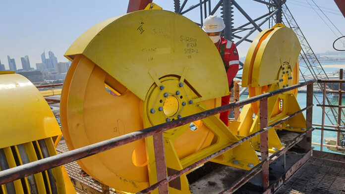 Sparrows technician works on a crown block installation and final inspection on a drill rig derrick