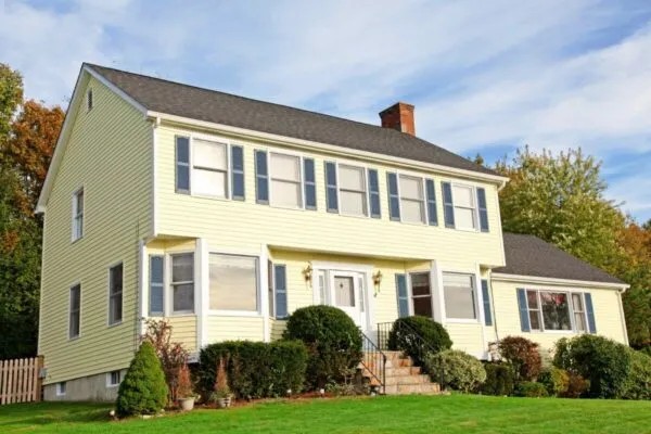 Yellow New England Style colonial house | Rhino Shield coating in demand as option for replacing metal and vinyl siding