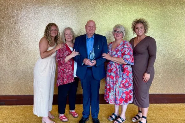 Aiken accepts his award at the Leadership Celebration Luncheon as part of the 2023 MWEA Annual Conference. Pictured from left to right: Granddaughter, Mackenzie Fris, Wife, Diane, Steve, daughter, Cori Fris, and Granddaughter, Taylor Fris. | Steve Aiken earns highest MWEA honor