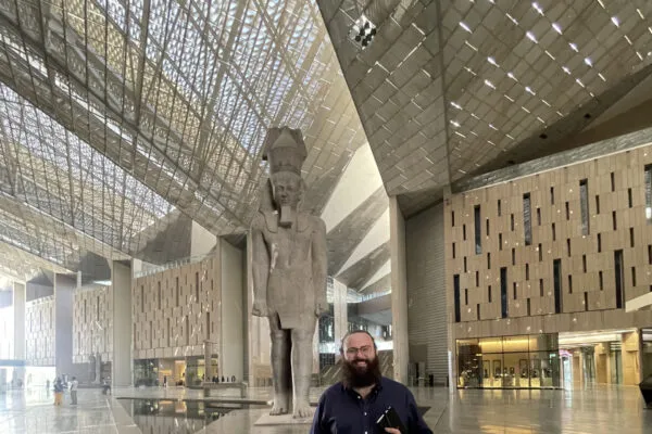 Civil+Structural Engineer Media Editor Luke Carothers poses while touring the Grand Egyptian Museum.  Statue features likeness of Ramesses II and stands in the GEM's atrium.  | A Letter from the Editor