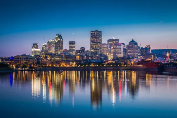 A night-time city scape of Quebec with the building lights reflecting onto the water. | Atlas Tube Introduces HSS Connections Hub™ to New Market at the Canadian Steel Conference